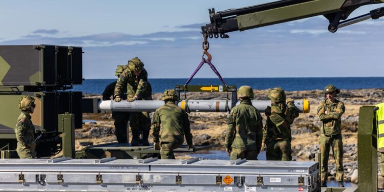 Soldiers from the Air Defense Battalion at Evenes load a NASAMS launcher with an AIM-120C-7 AMRAAM missile during Exercise Silver Arrow at Nordmela