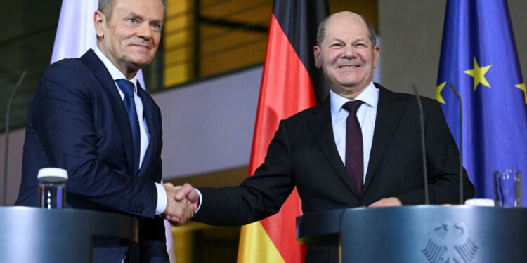 German Chancellor Olaf Scholz shakes hands with Polish Prime Minister Donald Tusk at a press conference, at the Chanceller...