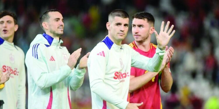 spain s fabian ruiz alvaro morata and aymeric laporte celebrate after beating serbia 3 0 on tuesday photo afp