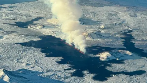 An aerial view of lava pouring from a volcanic fissure