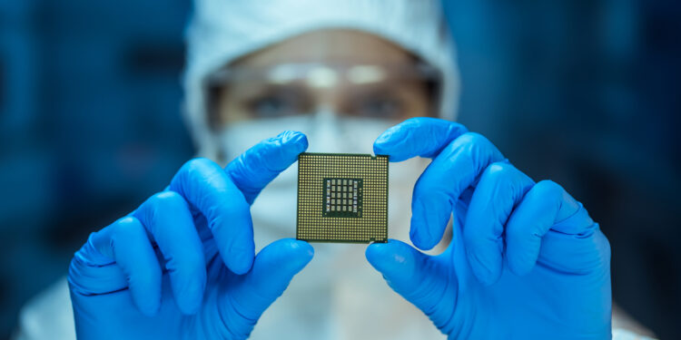 Engineer analyzing computer chip in laboratory