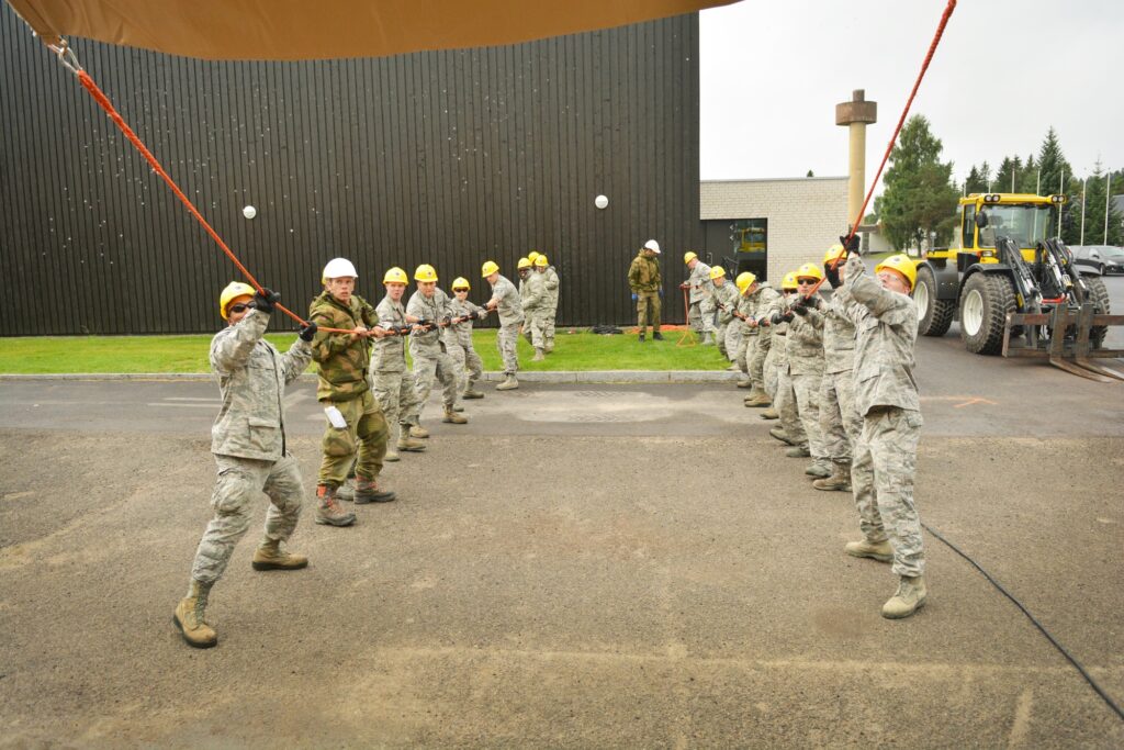 Members of the Texas Air National Guard's 149th Civil Engineering Squadron, a subordinate unit of the 149th Fighter Wing, based at Joint Base San Antonio - Lackland, Texas, help assemble a steel-frame structure at the Norwegian Military Academy (Krigsskolen), at Camp Linderud, in Oslo, Norway, Aug. 16, 2013. The 149th Fighter Wing's 149th Civil Engineering Squadron was in Norway as part of the U.S. National Guard Bureau's deployment for training program to train with members of the Royal Norwegian armed forces. (U.S. Air National Guard photo by Staff Sgt. Phil Fountain / Released)