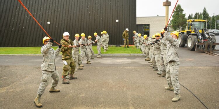 Members of the Texas Air National Guard's 149th Civil Engineering Squadron, a subordinate unit of the 149th Fighter Wing, based at Joint Base San Antonio - Lackland, Texas, help assemble a steel-frame structure at the Norwegian Military Academy (Krigsskolen), at Camp Linderud, in Oslo, Norway, Aug. 16, 2013. The 149th Fighter Wing's 149th Civil Engineering Squadron was in Norway as part of the U.S. National Guard Bureau's deployment for training program to train with members of the Royal Norwegian armed forces. (U.S. Air National Guard photo by Staff Sgt. Phil Fountain / Released)