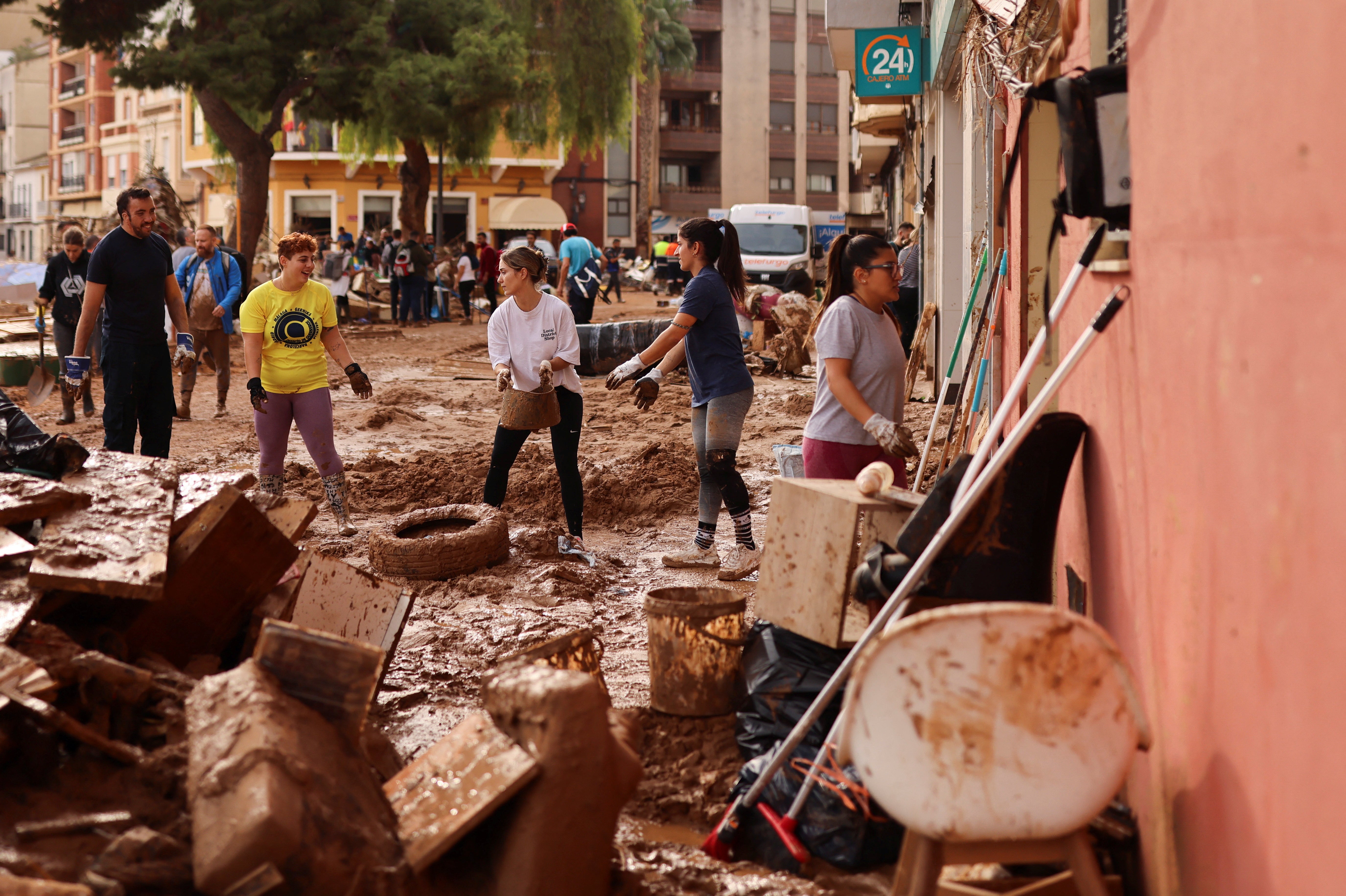 Volunteers and locals help to clean up following heavy rains that caused floods in Paiporta