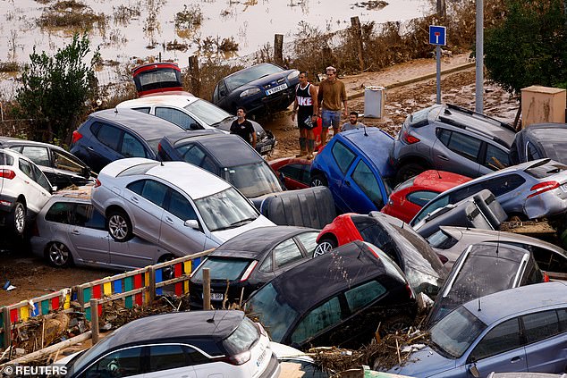 People stand next to stranded cars, following floods in Valencia, Spain, October 31, 2024