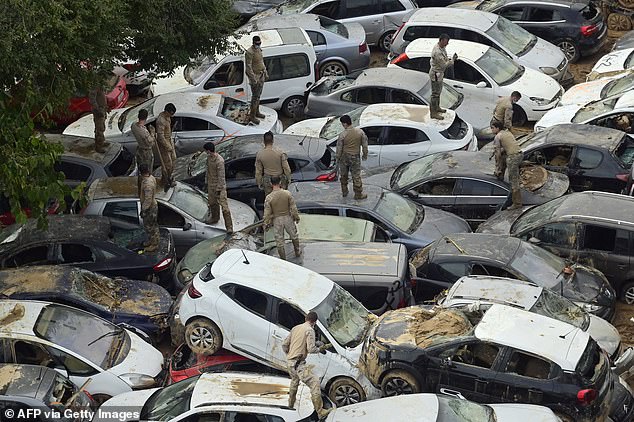 Soldiers search wrecked cars damaged by flooding in Massassana, region of Valencia