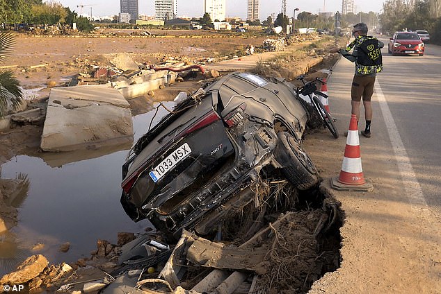 Jorge Tarazona stands next to a car in Paiporta, Valencia, Spain, Wednesday, November 5