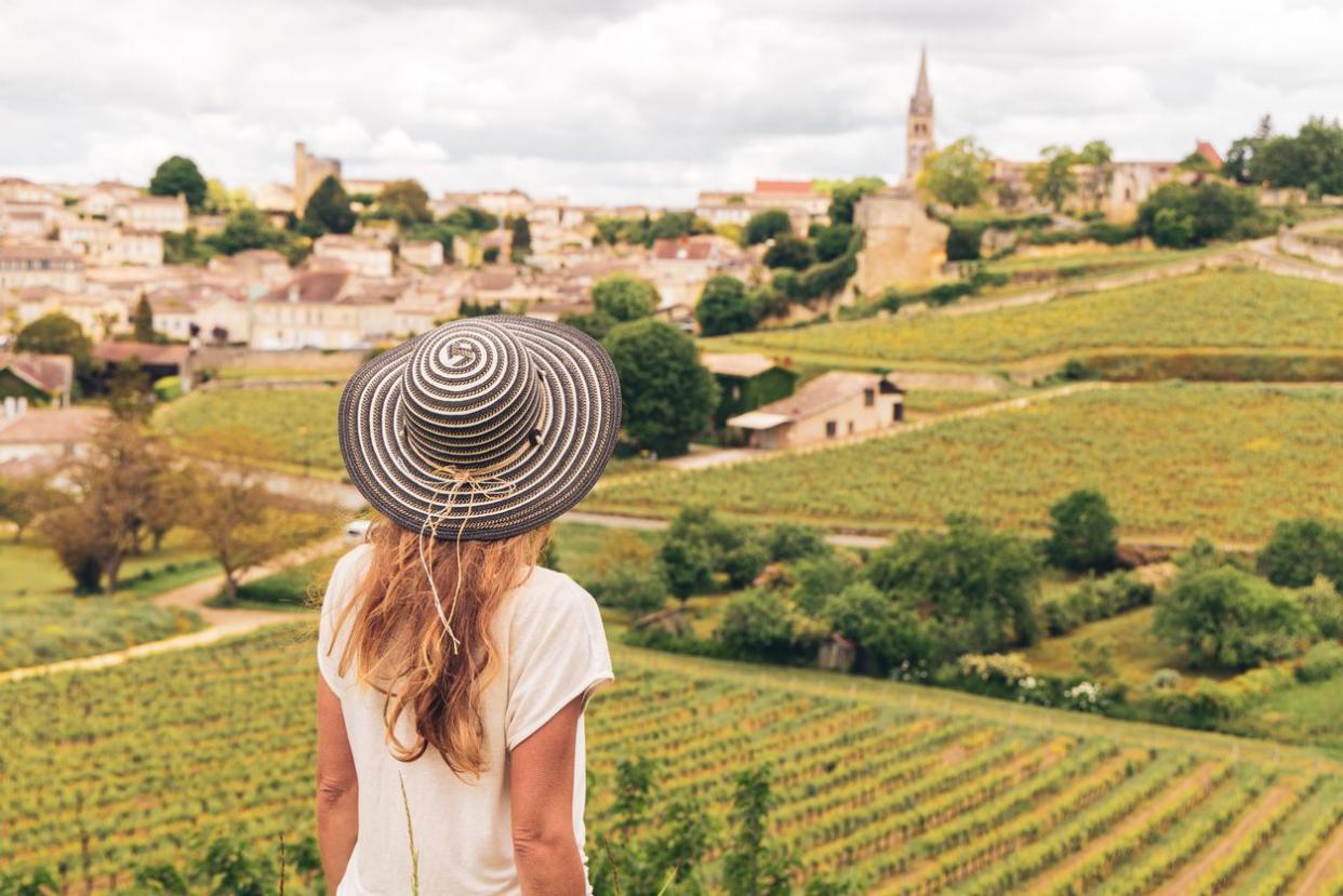 Rear view of woman looking at green vineyard in Bordeaux region, Saint Emilion- France