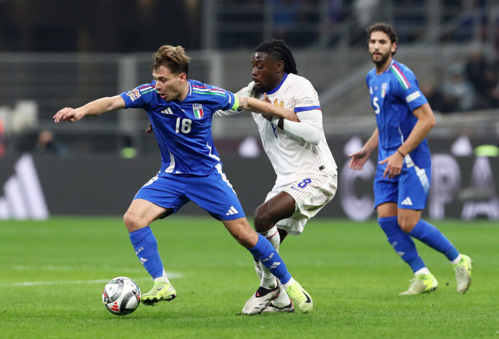 MILAN, ITALY - NOVEMBER 17: Nicolo Barella of Italy runs with the ball whilst under pressure from Manu Kone of France during the UEFA Nations League 2024/25 League A Group A2 match between Italy and France at San Siro on November 17, 2024 in Milan, Italy. (Photo by Marco Luzzani/Getty Images)