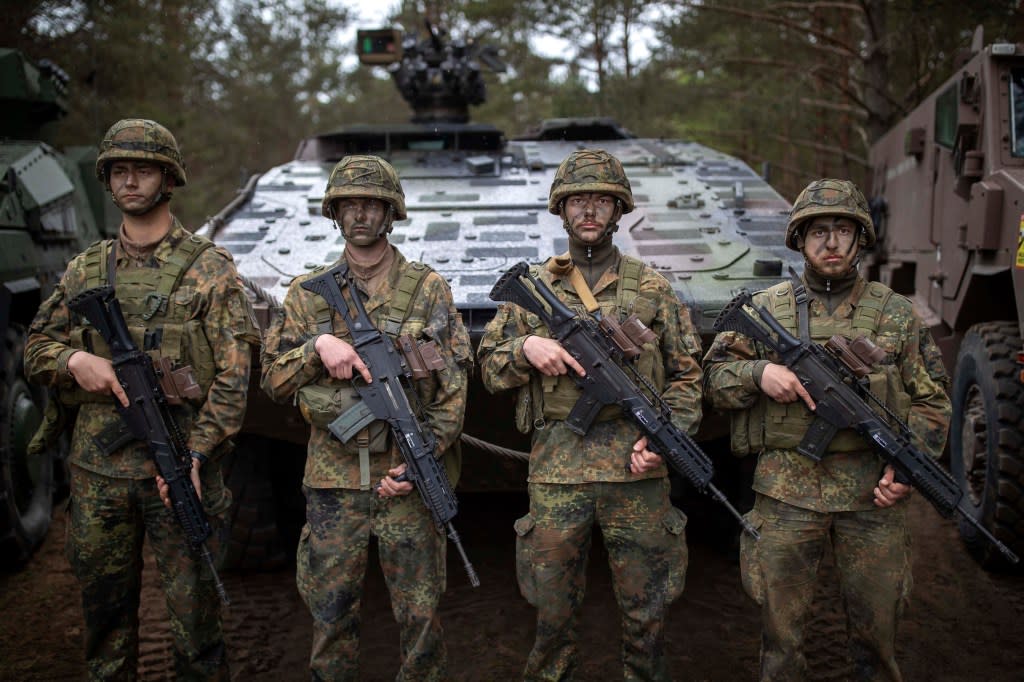 German army soldiers wait to greet German Chancellor Olaf Scholz upon his arrival at a training range. AP