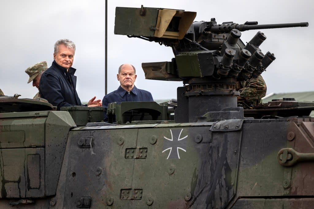 German Chancellor Olaf Scholz and Lithuania’s President Gitanas Nauseda ride on an armored military vehicle during the Lithuanian-German military exercise ‘Grand Quadriga’ at a training range. AP