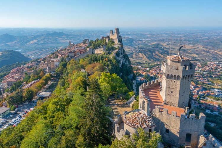 View of San Marino, with fortress and luscious greenery.