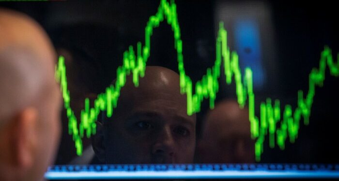 A trader watches his chart while working on the floor of the New York Stock Exchange