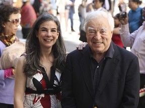 Arthur Frommer and his daughter, Pauline Frommer pose among tourists in the Wall Street area in New York, May 20, 2012.