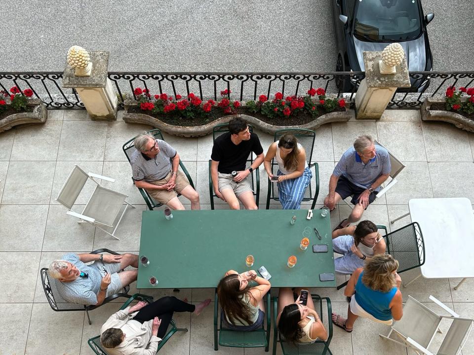 Group of people sitting around table on a terrace with drinks