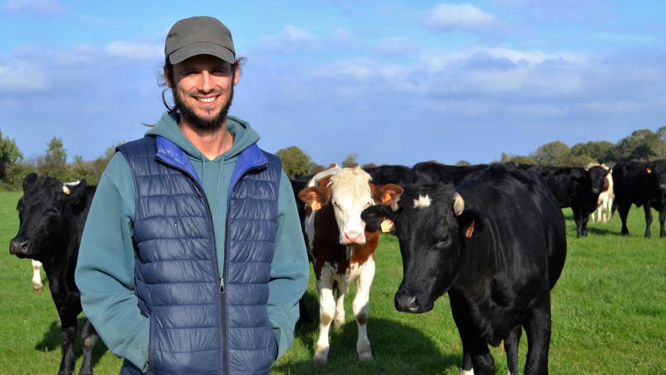 Farmer Antoine Gomel stands in front of his cattle