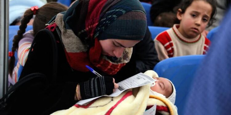 Syrian refugee filling out papers with their child