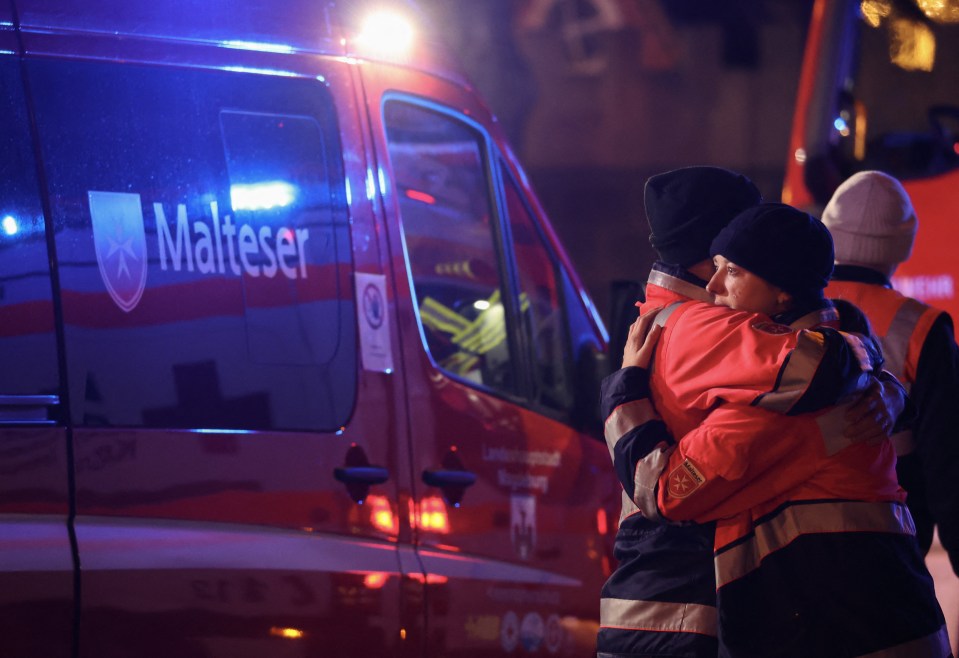 Rescue workers hug following Friday’s Christmas market atrocity in Magdeburg