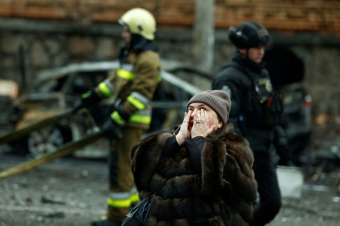 A woman reacts at the scene of missile damage.