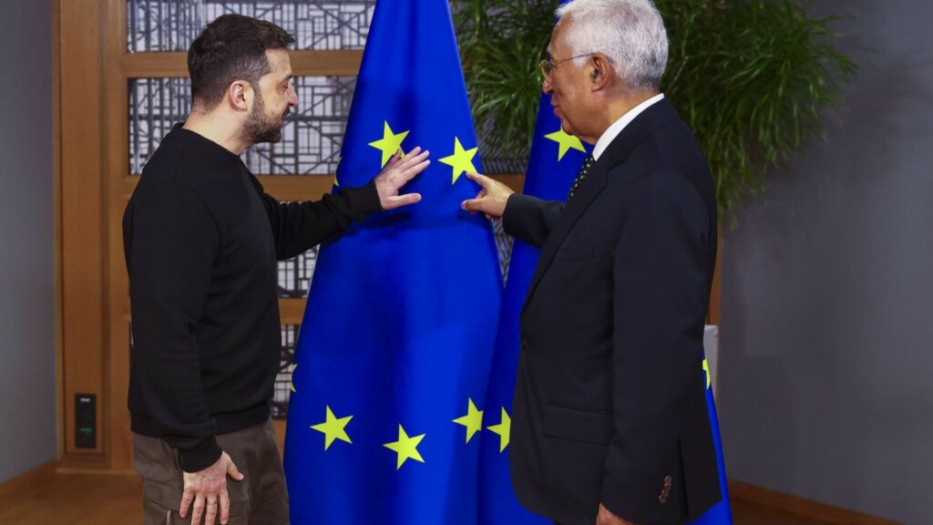 Two men pointing at a flag