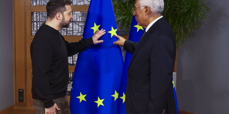 Two men pointing at a flag