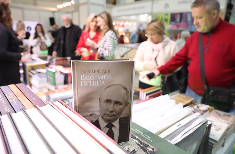 Muscovites browse through books with a book about Vladimir Putin in the foreground.