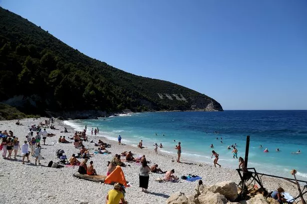 Tourists sunbath near the Albanian city of Vlore, on Mediterranean coast, on July 30 2024