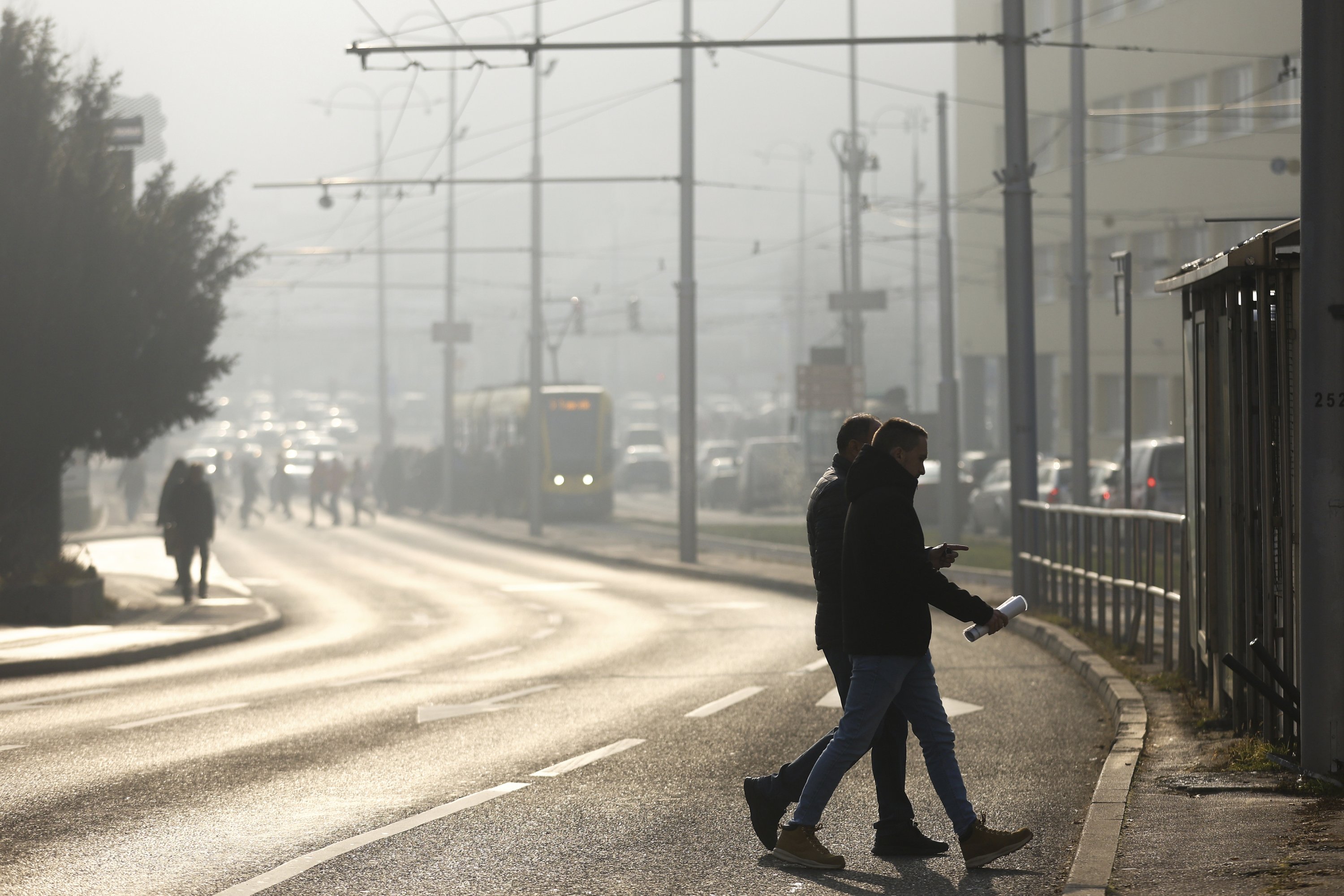 People cross the street shrouded by pollution haze as smog covers Sarajevo, Bosnia-Herzegovina, Dec. 19, 2024. (AP Photo)