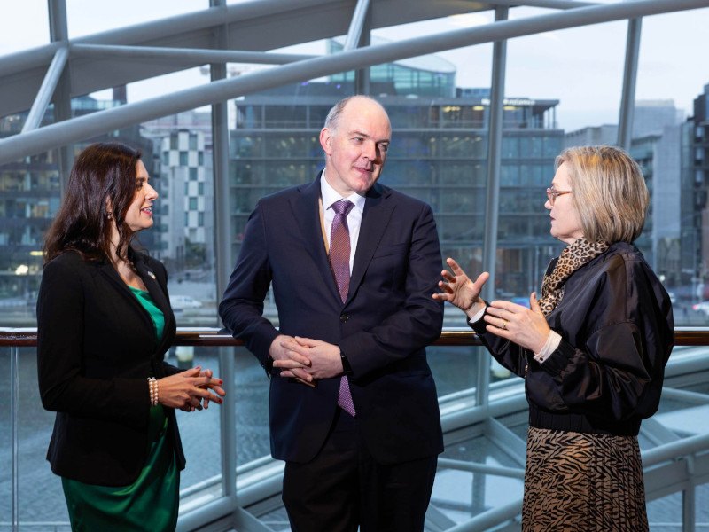 Two women and a man in the centre talking to each other.