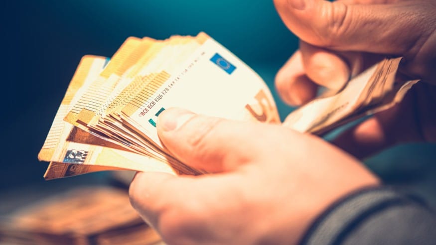 Person counting a large stack of EURO banknotes