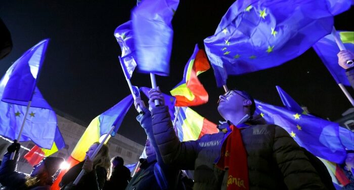 People shout slogans and wave Romanian and EU flags during a Pro-Europe rally