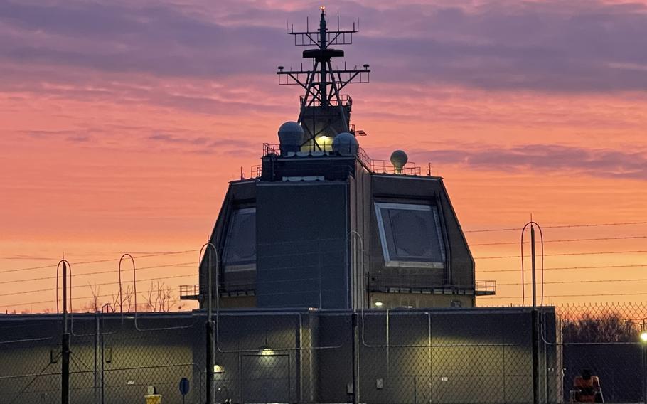 The missile defense system with orange of the low sun in the background.