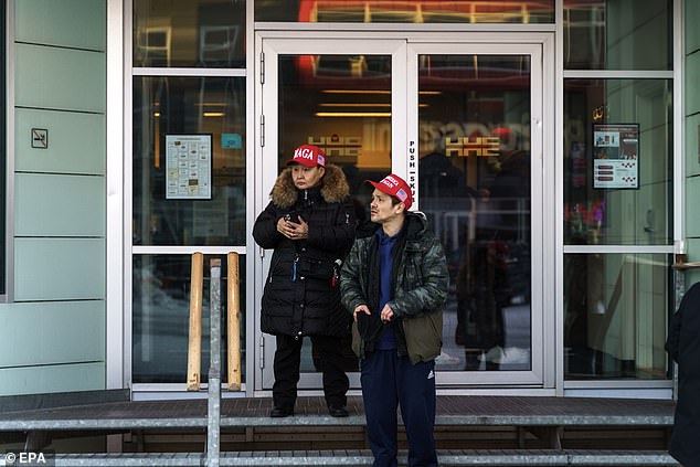 Residents wearing MAGA hats stand in front of the Hotel Hans Egede during Donald Trump Jr.'s (not pictured) visit to Nuuk, Greenland