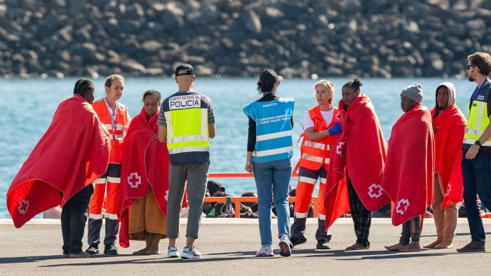 A Spanish police officer and Frontex officer receive migrants arriving in the Lanzarote port of Arrecife this week. A baby boy was born on a small, crowded boat carrying 60 people on the deadly Atlantic migration route from Africa to the Canary Islands