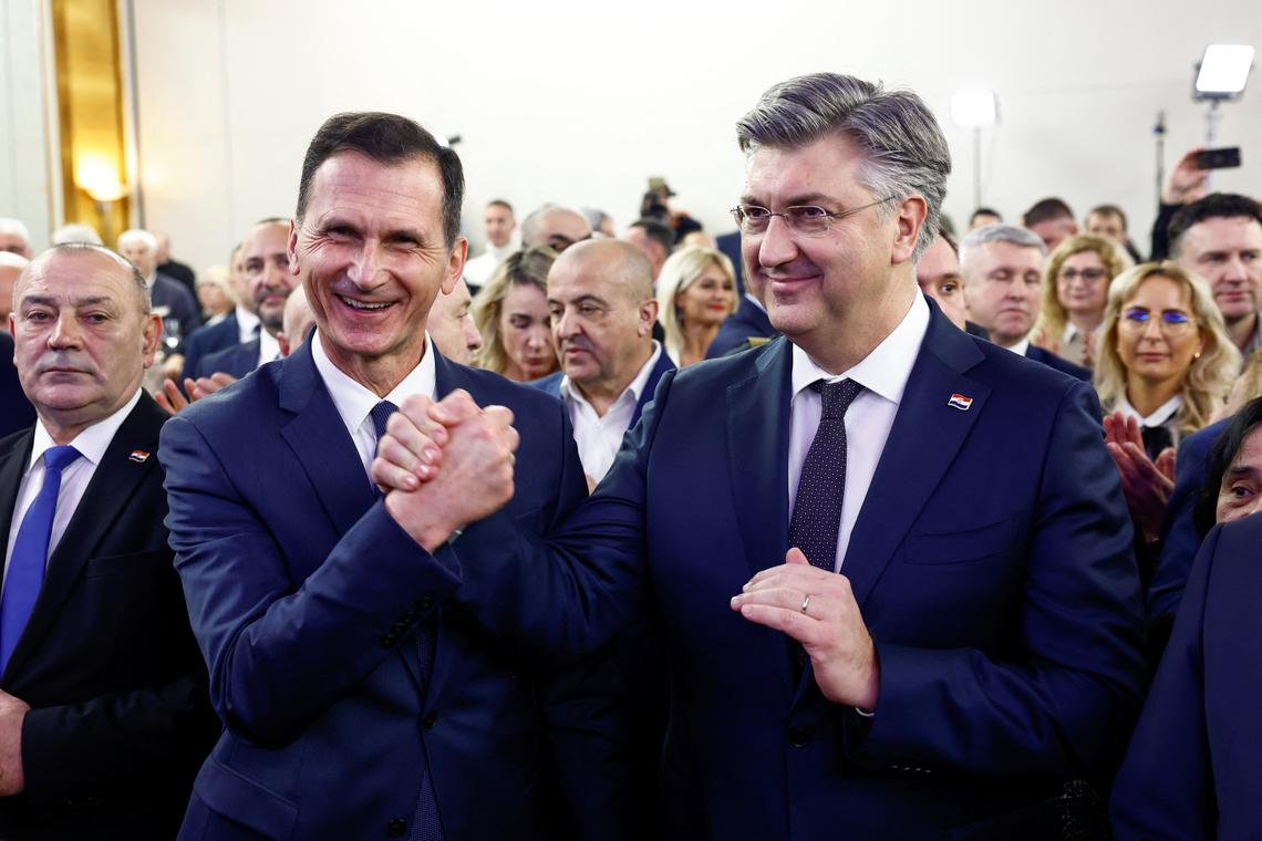 Croatia's Prime Minister Andrej Plenkovic holds hands with Presidential candidate Dragan Primorac on the day of the second round of the presidential election in Zagreb, Croatia, January 12, 2025. REUTERS/Borut Zivulovic