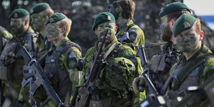 U.S. troops stand during military drills at Adazi Military base in Kadaga, Latvia, Tuesday, March. 8, 2022. (AP Photo/Roman Koksarov)