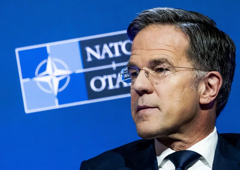 Close-up of Mark Rutte in front of a NATO logo.