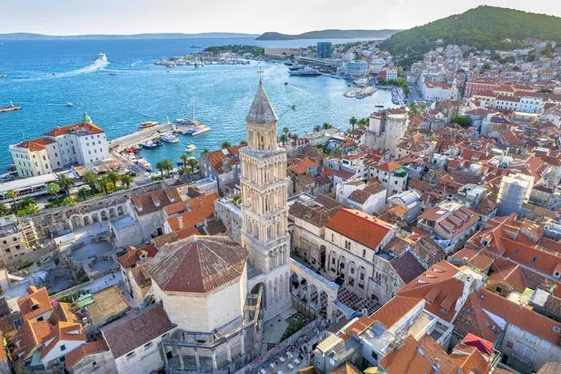 Aerial view of Diocletian's Palace, a UNESCO World Heritage Site, in the old town of Split. Showing red-brick roofs and the sea. 