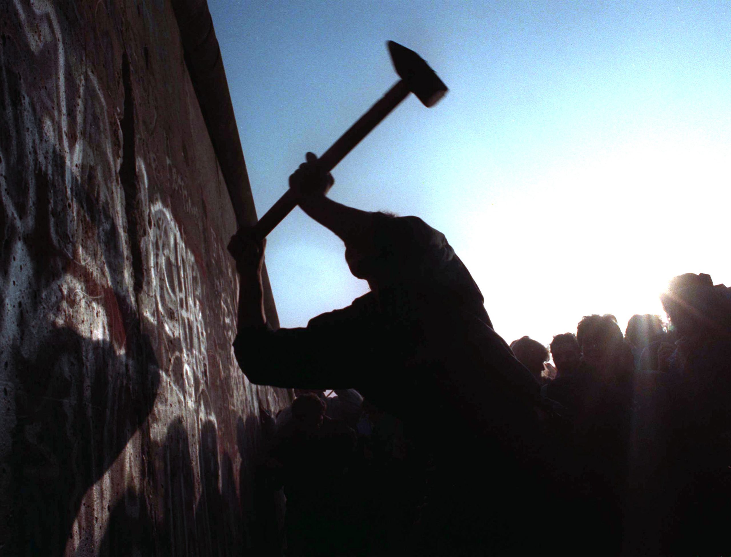 A man hammers away at the Berlin Wall on 12 Nov, 1989