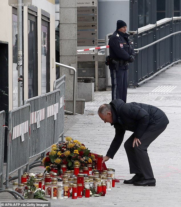 Austria's Interior Minister Gerhard Karner places a candle on February 16, 2025 at the site where a man randomly attacked passers-by with a knife and stabbed to death a teenager and wounded five other people in Villach, Austria