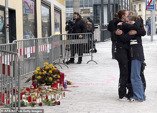 People have been seen mourning and comforting each other todayat a makeshift memorial of candles and flowers placed near the scene of the rampage