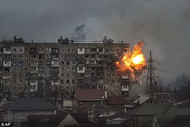 An explosion erupts from an apartment building in Mariupol in March 2022