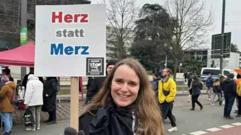 Annika, 29, waves a placard that reads in German 