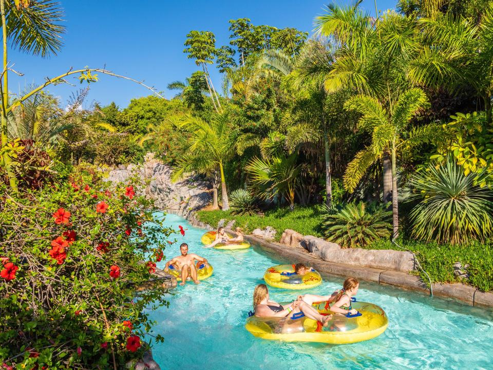 People floating down a lazy river in a water park.