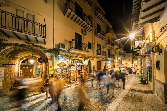 Walk this way… people stroll through the Piazza del Duomo or Cathedral square in Cefalu, Sicily.